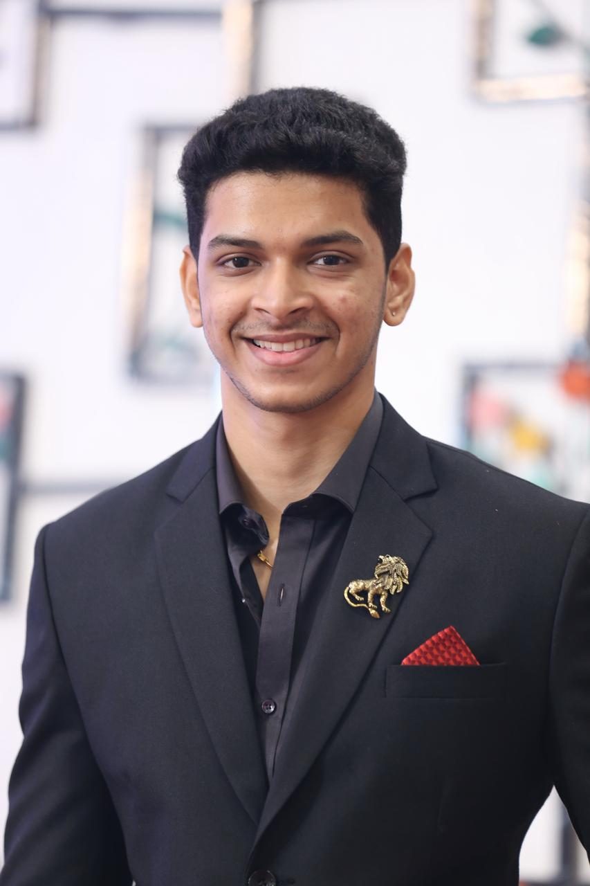 Himanshu, smiling in a black suit